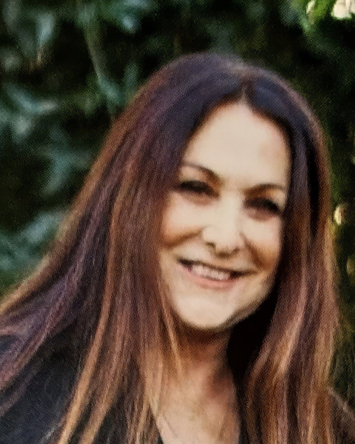 Lisa Baker, smiling outdoors, her long auburn hair over her shoulders